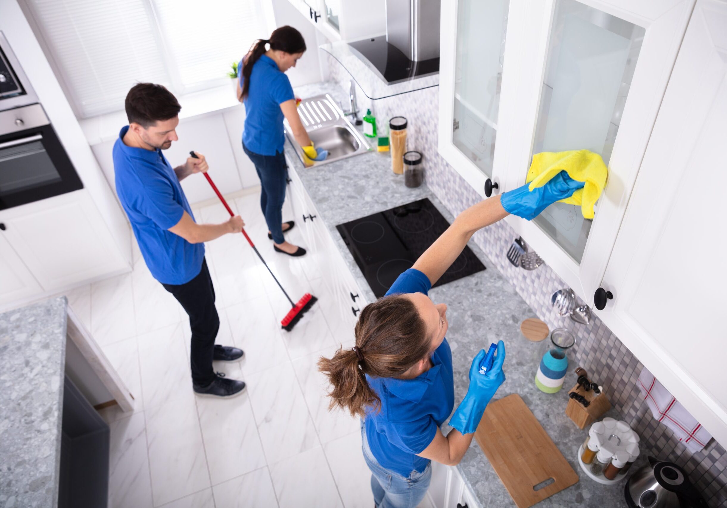 Group,Of,Young,Janitors,In,Uniform,Cleaning,Kitchen,At,Home